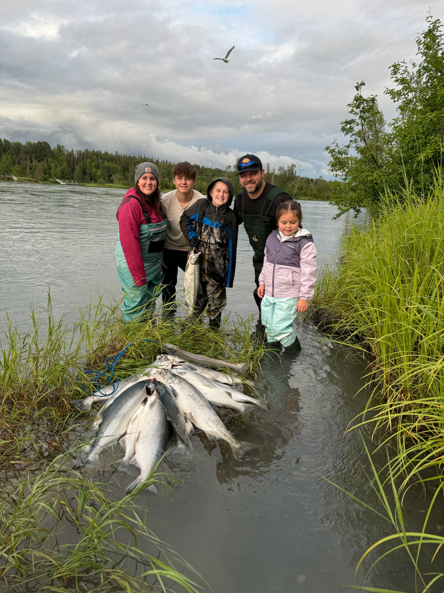 Family with a limit of sockeye on the riverbank